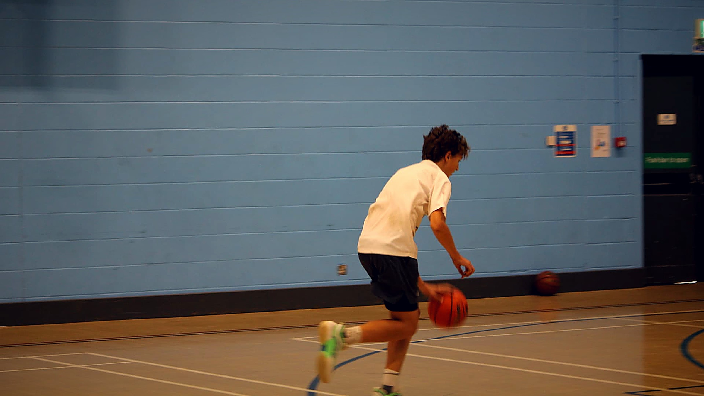 A participant driving with the ball across the court during a PHB session