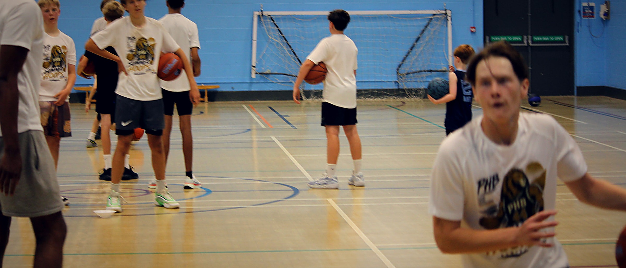 Young people taking part in an active Pro Hoops Blueprint basketball session with Coach Shane in a sports hall