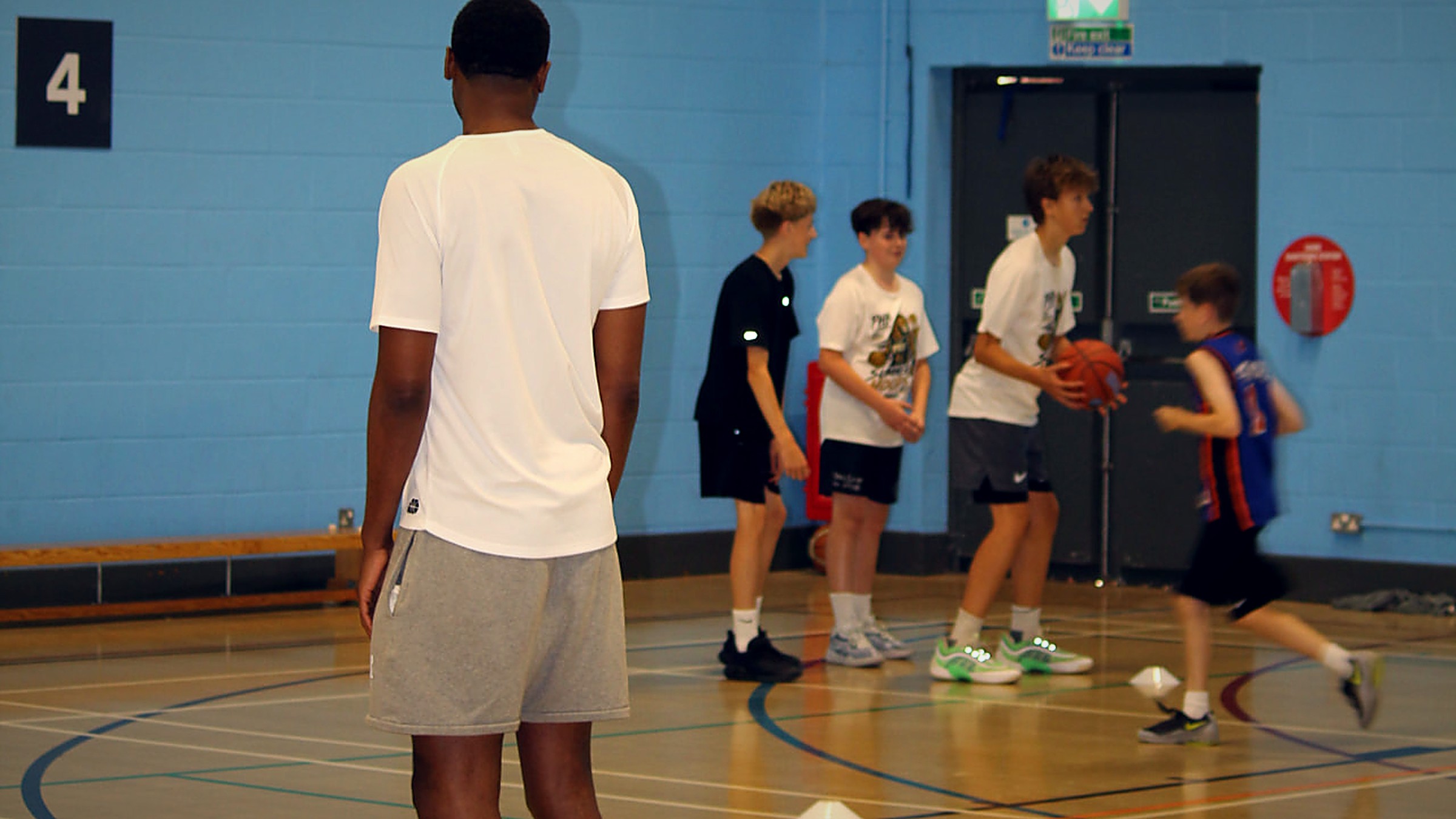 Coach Shane observing young people during a structured Pro Hoops Blueprint basketball activity